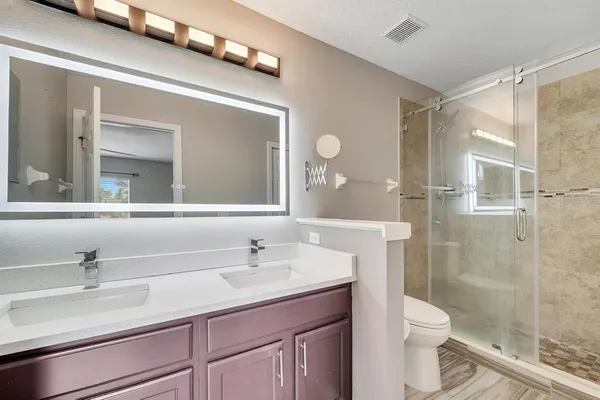 a bathroom with a sink a toilet and shower