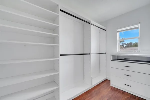 a view of walk in closet with empty racks