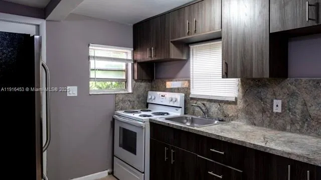 a kitchen with granite countertop wooden cabinets and white appliances
