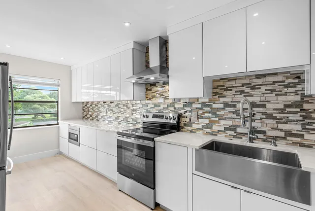 a kitchen with white cabinets stainless steel appliances and sink