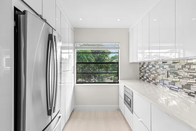 a kitchen with stainless steel appliances granite countertop a refrigerator and a sink