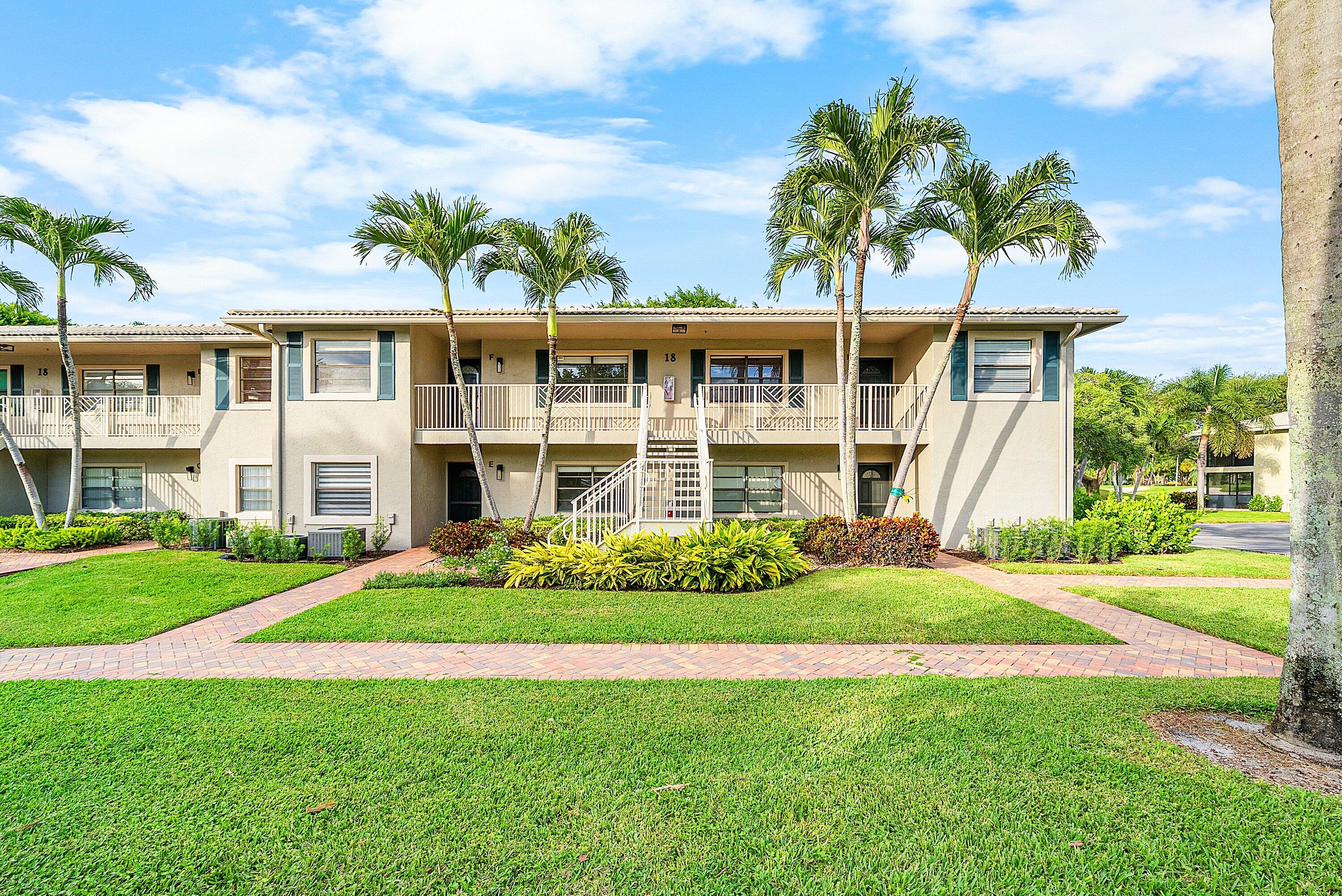 18 Stratford Drive East, Unit F Boynton Beach, FL 33436 - Photo 2 of 54 a front view of a house with a garden