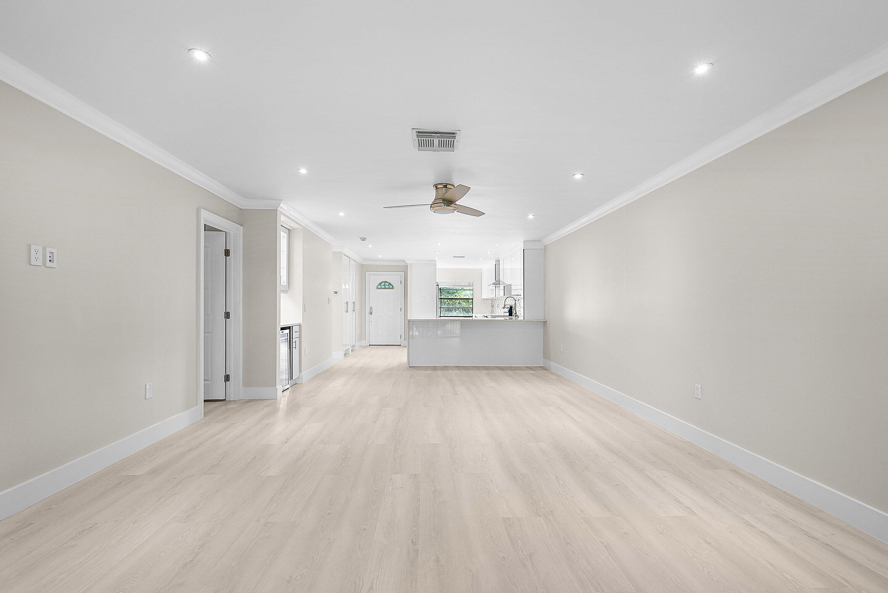 18 Stratford Drive East, Unit F Boynton Beach, FL 33436 - Photo 24 of 54 an empty room with wooden floor fan and windows