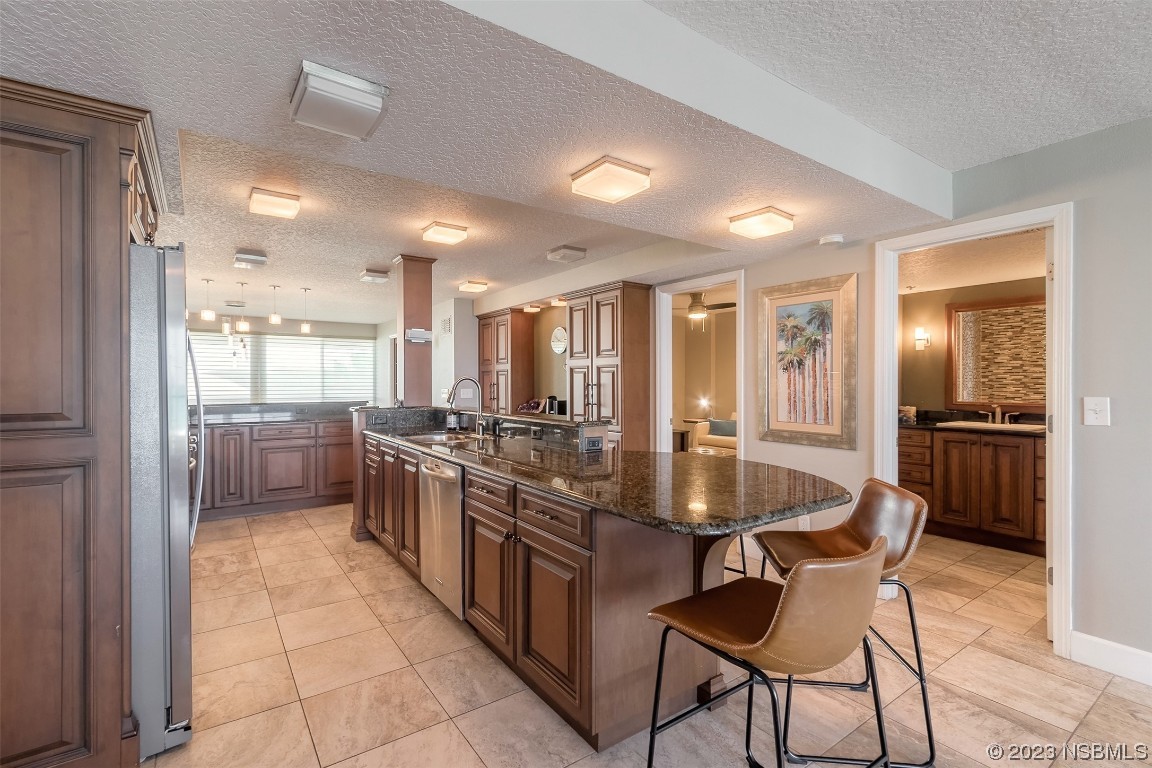 4545 South Atlantic Avenue, Unit 3204 Ponce Inlet, FL 32127 - Photo 37 of 58 a kitchen with stainless steel appliances granite countertop a sink and a refrigerator