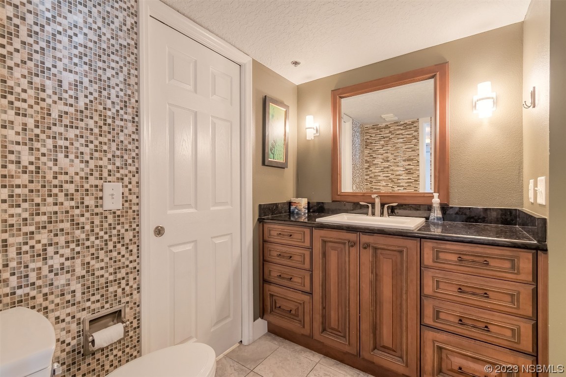 4545 South Atlantic Avenue, Unit 3204 Ponce Inlet, FL 32127 - Photo 41 of 58 a bathroom with a granite countertop sink a toilet and a mirror