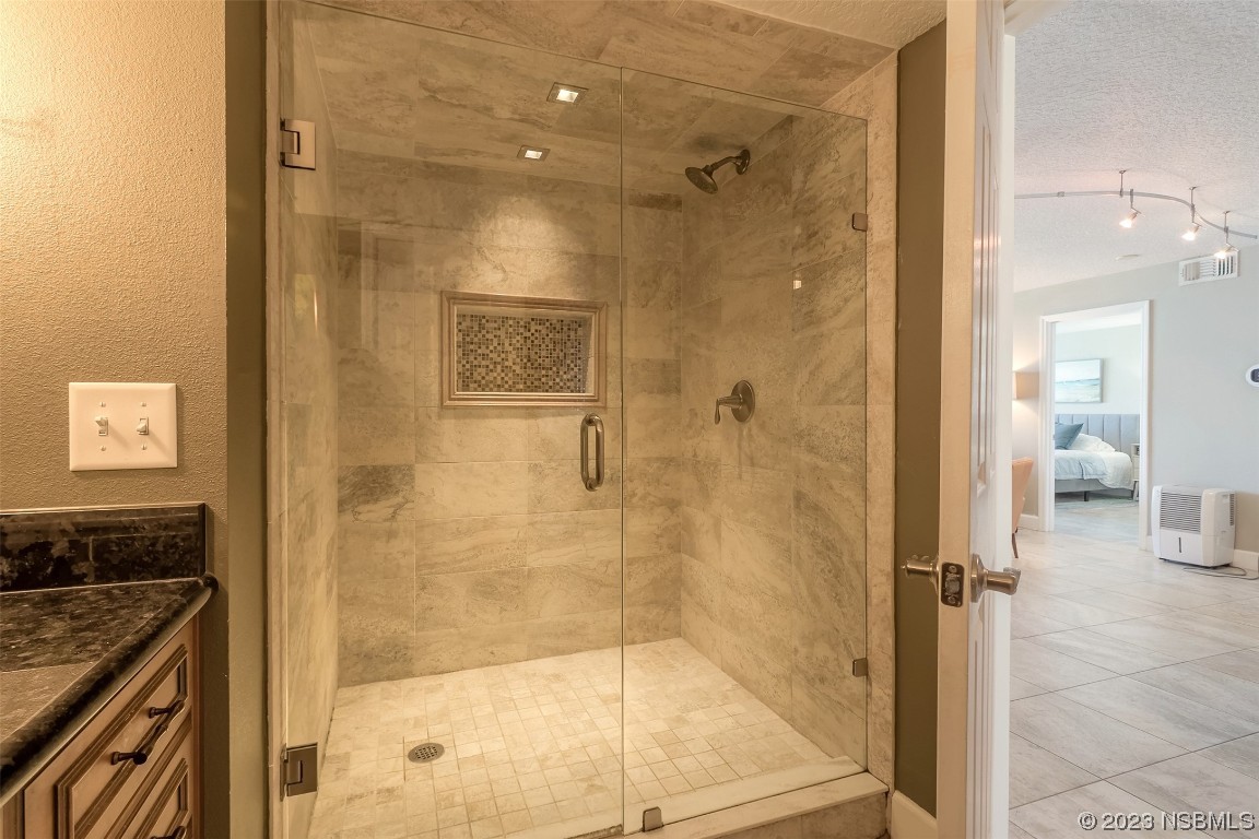 4545 South Atlantic Avenue, Unit 3204 Ponce Inlet, FL 32127 - Photo 42 of 58 a bathroom with a granite countertop shower mirror and a bathtub
