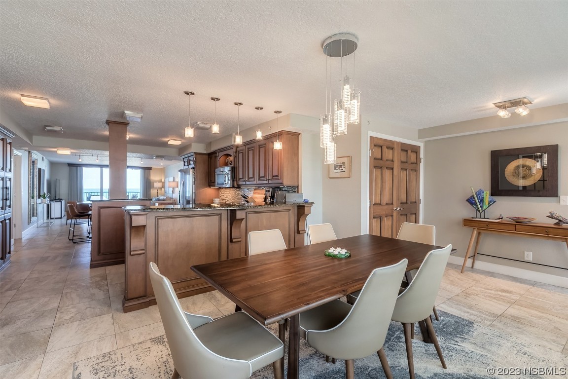 4545 South Atlantic Avenue, Unit 3204 Ponce Inlet, FL 32127 - Photo 44 of 58 a dining room with kitchen island furniture and a kitchen view