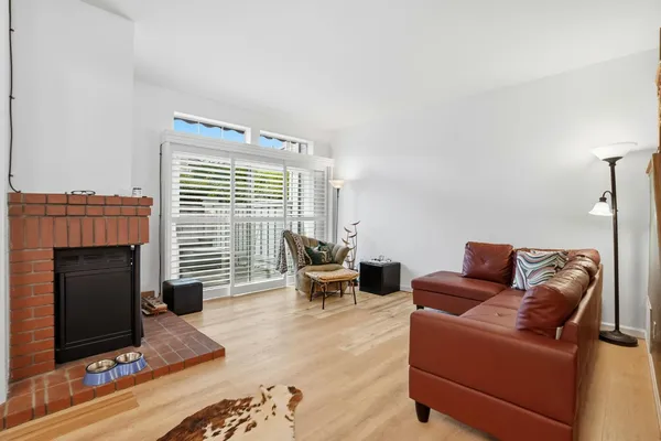 a living room with furniture a fireplace and a floor to ceiling window