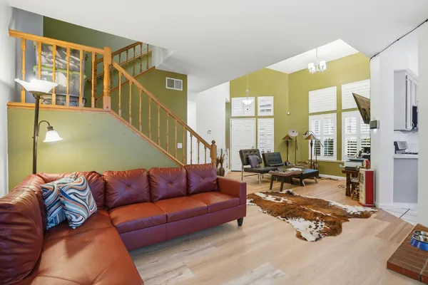 a living room with furniture kitchen view and large windows