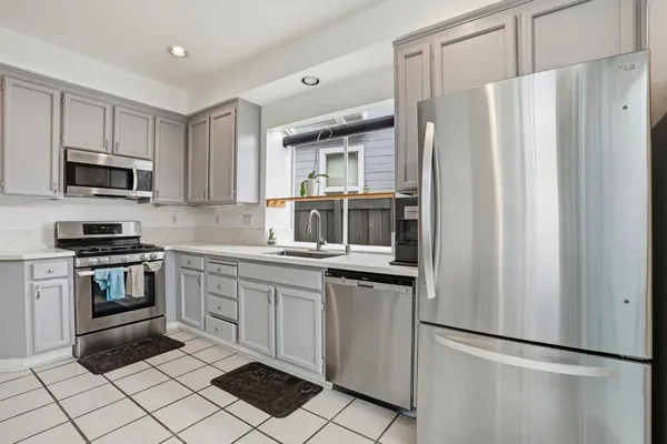 a kitchen with white cabinets and stainless steel appliances