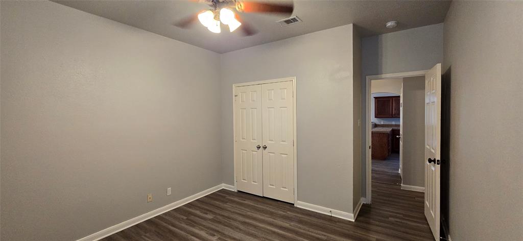 2616 South 2nd Street Waco, TX 76706 - Photo 18 of 29 Spacious bedroom featuring wood-finish flooring, ceiling fan with integrated lighting, and dual closets with six-panel doors