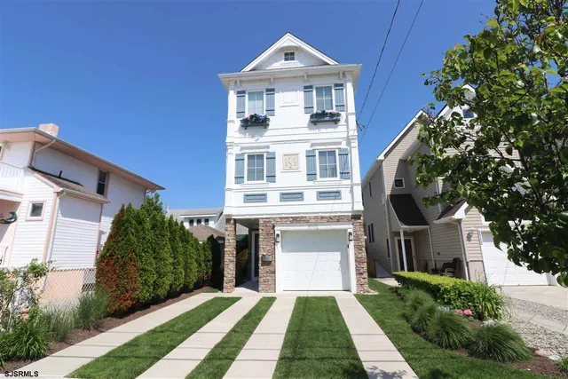 a front view of a house with a yard and trees