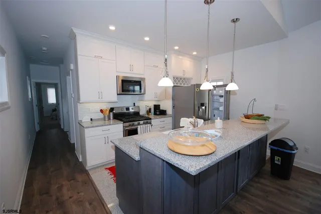 a kitchen with a sink a counter top space and stainless steel appliances