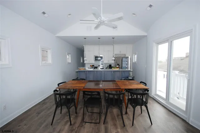 a kitchen with stainless steel appliances kitchen island a table and chairs in it