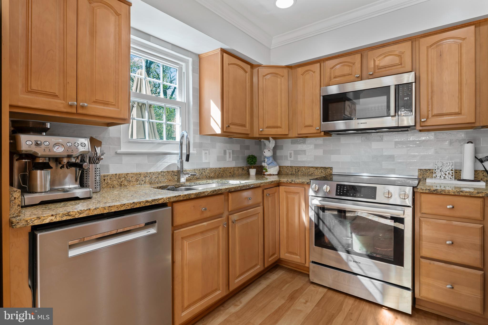 10267 Green Holly Terrace Silver Spring, MD 20902 - Photo 14 of 52 a kitchen with granite countertop white cabinets stainless steel appliances and a sink