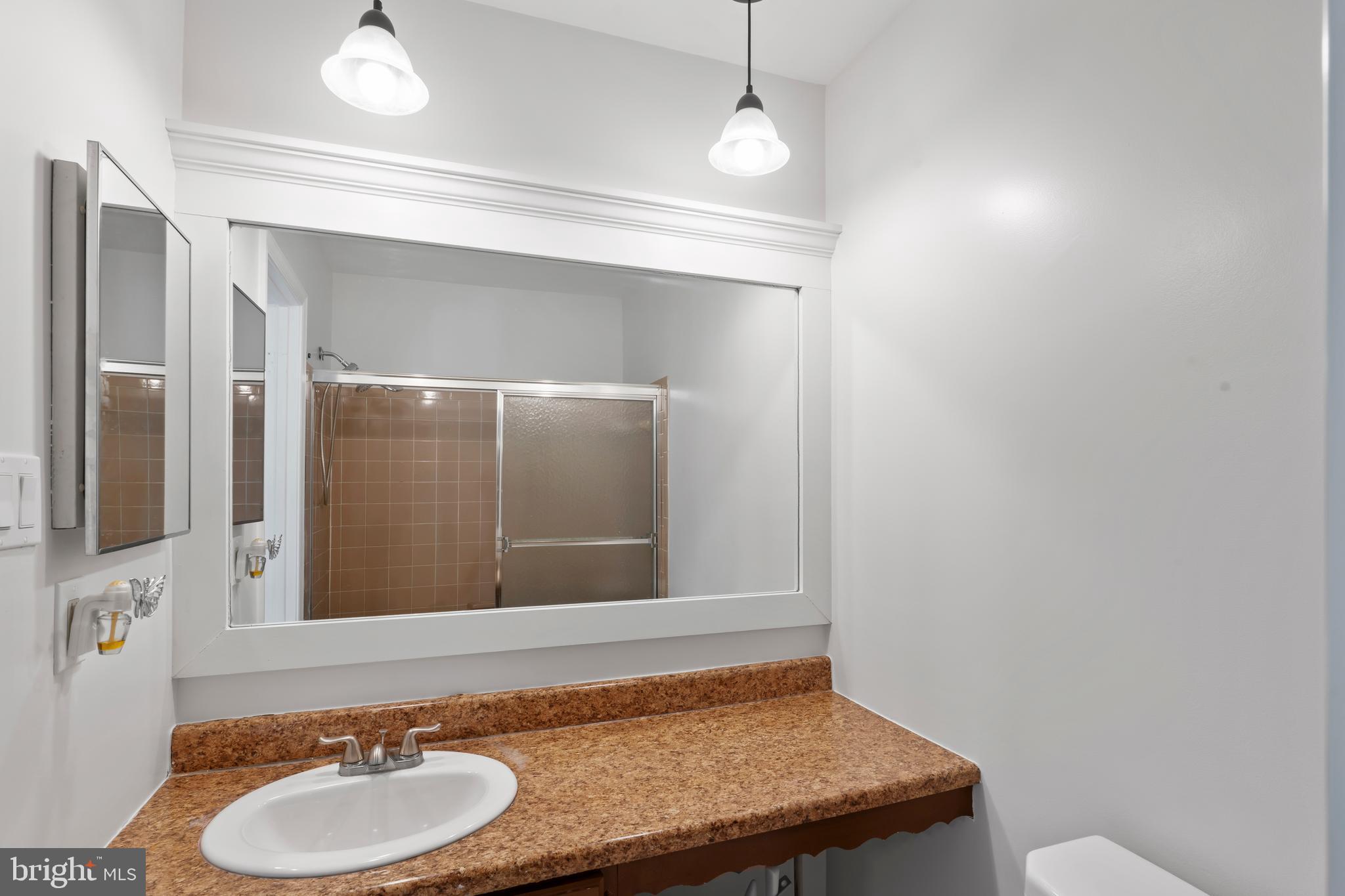 10267 Green Holly Terrace Silver Spring, MD 20902 - Photo 28 of 52 a bathroom with a granite countertop sink and a mirror