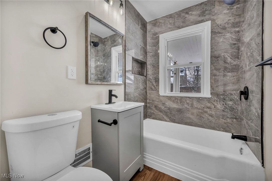 13614 Cedar Road Cleveland, OH 44118 - Photo 12 of 46 Bathroom featuring visible vents, toilet, wood finished floors, shower combination, and vanity