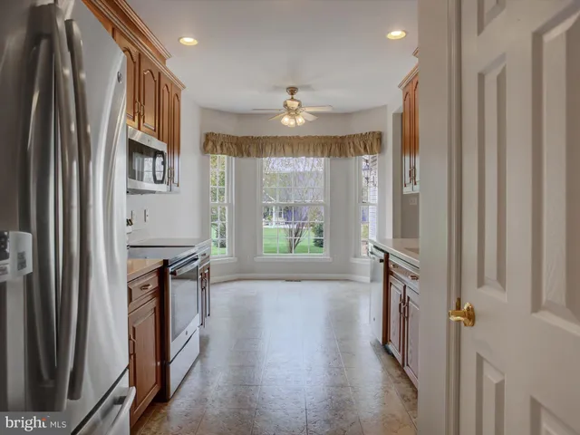 a kitchen with stainless steel appliances granite countertop a refrigerator a stove and a sink