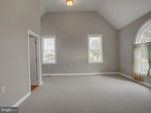 an empty room with a window and a chandelier fan