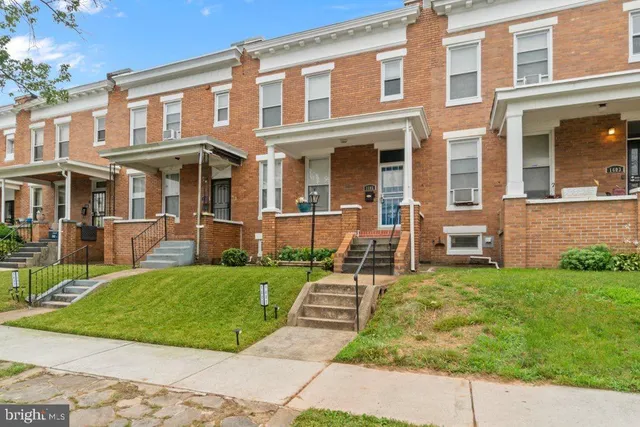 front view of a brick house with a yard
