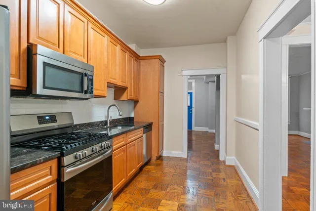 a kitchen with stainless steel appliances granite countertop a stove microwave and cabinets