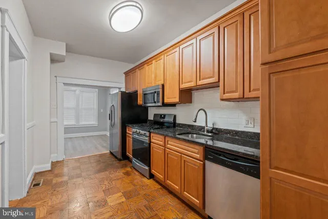 a kitchen with stainless steel appliances granite countertop a stove a sink and a refrigerator