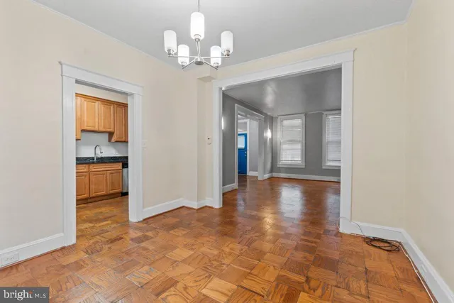 a view of a hallway with wooden floor and a kitchen