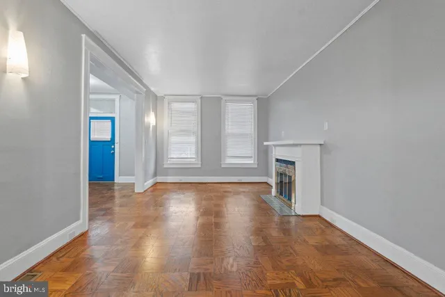 a view of empty room with wooden floor and fireplace