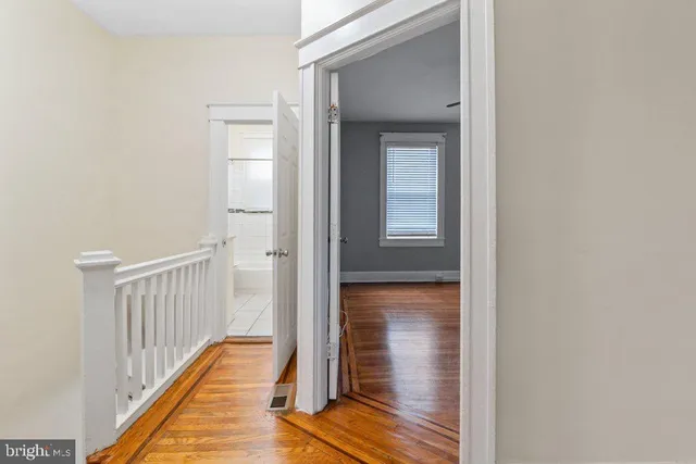 a view of a hallway with wooden floor and closet