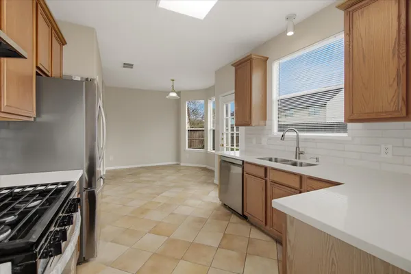 a kitchen with stainless steel appliances granite countertop a sink stove and refrigerator