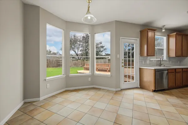 a view of kitchen with granite countertop a stove top oven a sink and a window