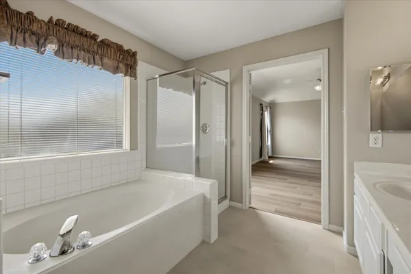 a bathroom with a tub shower and sink