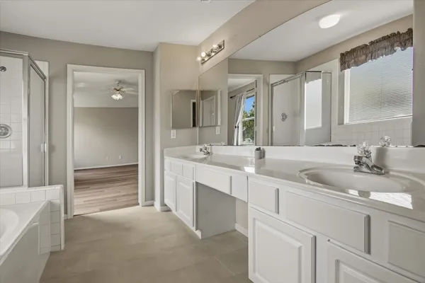 a bathroom with double vanity sinks and a bathtub