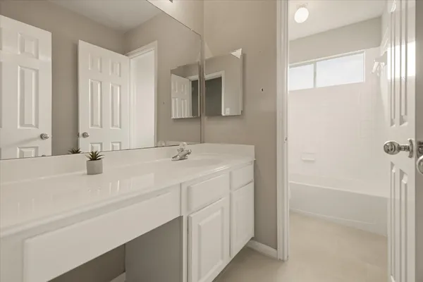 a bathroom with a double vanity sink a mirror and a bathtub