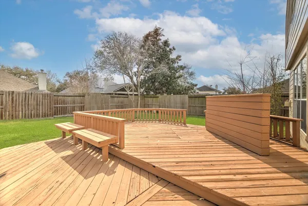 a view of a patio with wooden floor and iron fence
