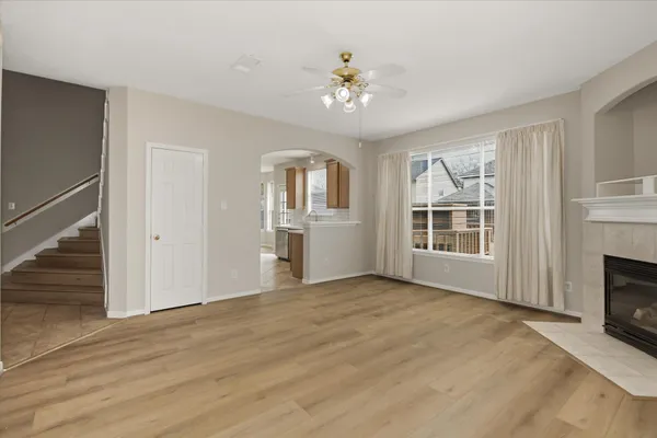 a view of an empty room with chandelier and wooden floor