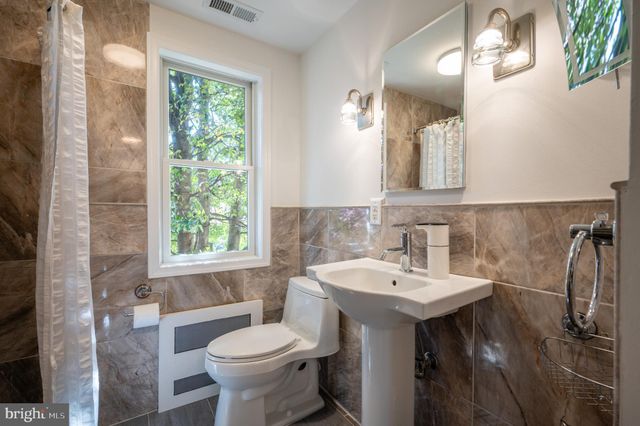 a bathroom with a sink toilet and a mirror