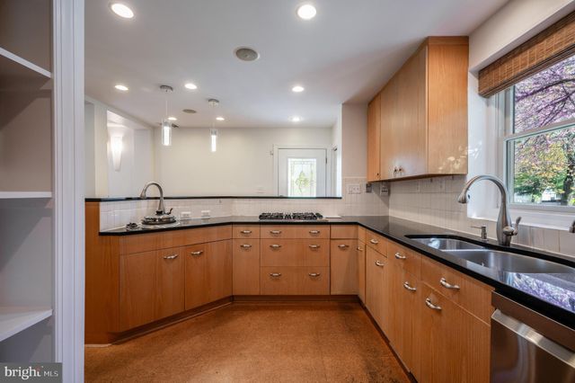 a large kitchen with stainless steel appliances granite countertop a sink and cabinets