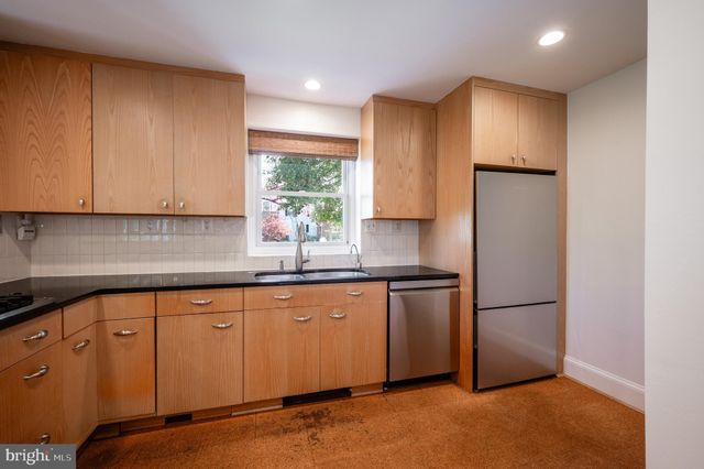 a kitchen with stainless steel appliances granite countertop a refrigerator a sink and a stove