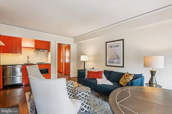 a living room with furniture a large window and wooden floor