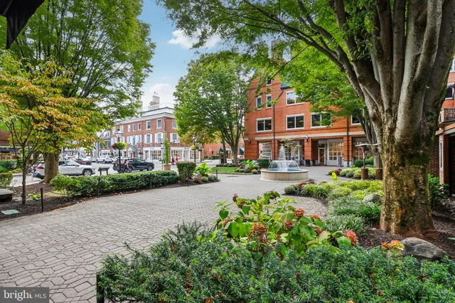 a front view of a house with a yard and fountain in middle