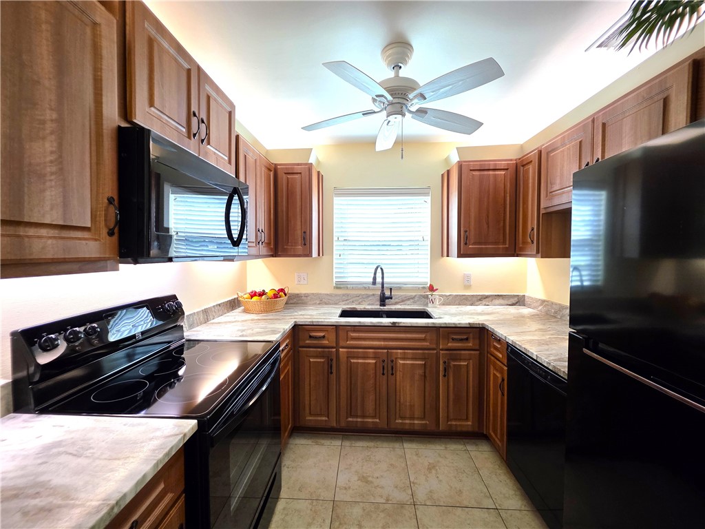 88 Crooked Tree Lane, Unit 107 Vero Beach, FL 32962 - Photo 6 of 33 a kitchen with stainless steel appliances a sink stove and refrigerator