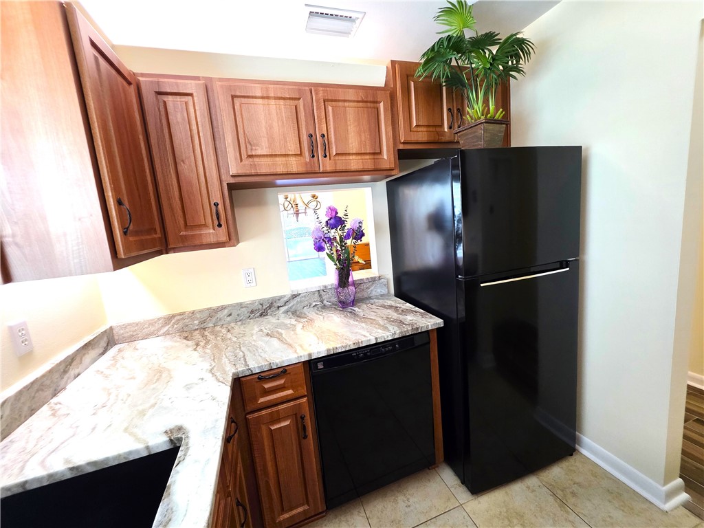 88 Crooked Tree Lane, Unit 107 Vero Beach, FL 32962 - Photo 7 of 33 a kitchen with a refrigerator and a sink