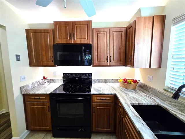 a kitchen with granite countertop a sink stove and cabinets