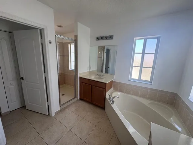 a bathroom with a tub sink and mirror