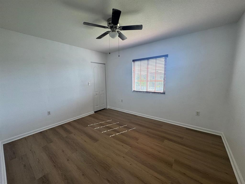 14044 Southwest 276th Way Homestead, FL 33032 - Photo 24 of 26 an empty room with wooden floor and windows