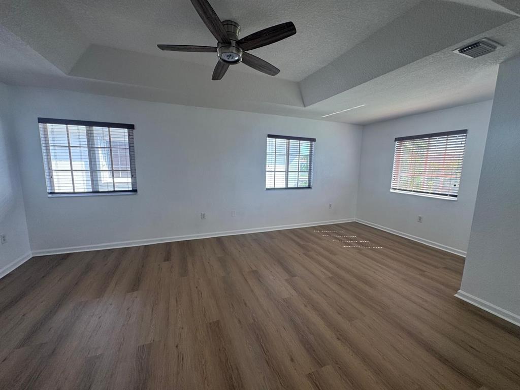 14044 Southwest 276th Way Homestead, FL 33032 - Photo 25 of 26 a view of empty room with wooden floor and fan
