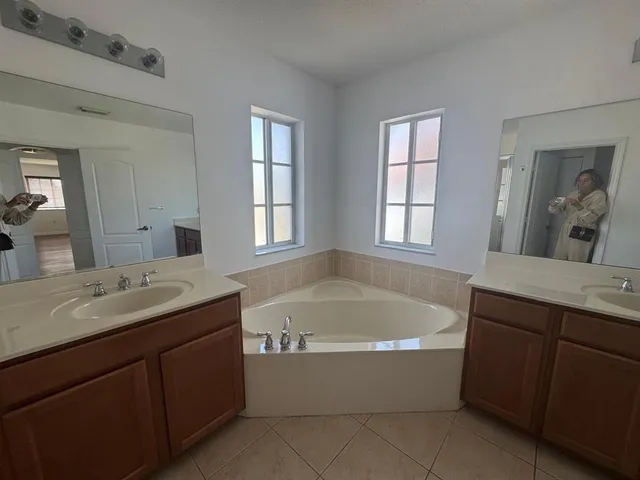 a bathroom with a granite countertop bathtub sink and mirror