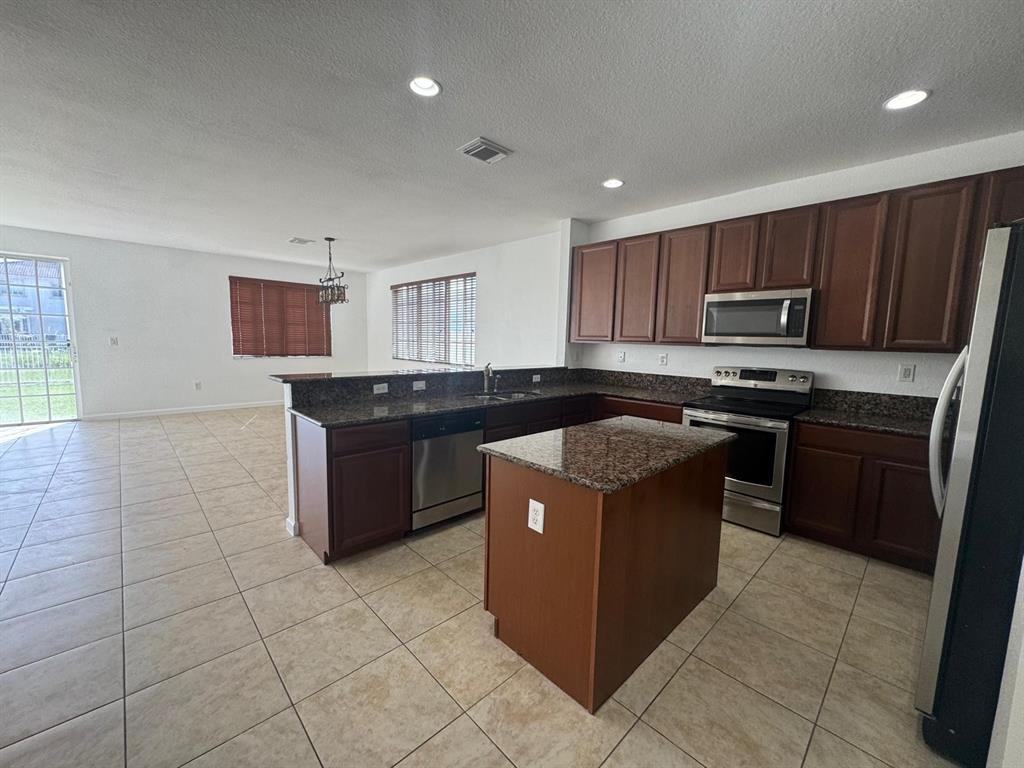 14044 Southwest 276th Way Homestead, FL 33032 - Photo 6 of 26 a kitchen with a stove top oven sink and cabinets