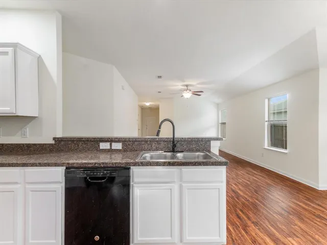 a bathroom with a granite countertop sink a mirror and a bathtub